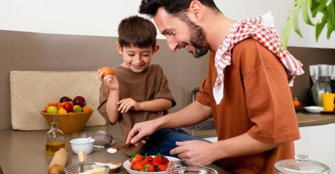 A young boy and his father cooking together