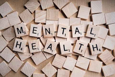 Blank Scrabble tiles with just the words Mental Health on tiles laying on top. 